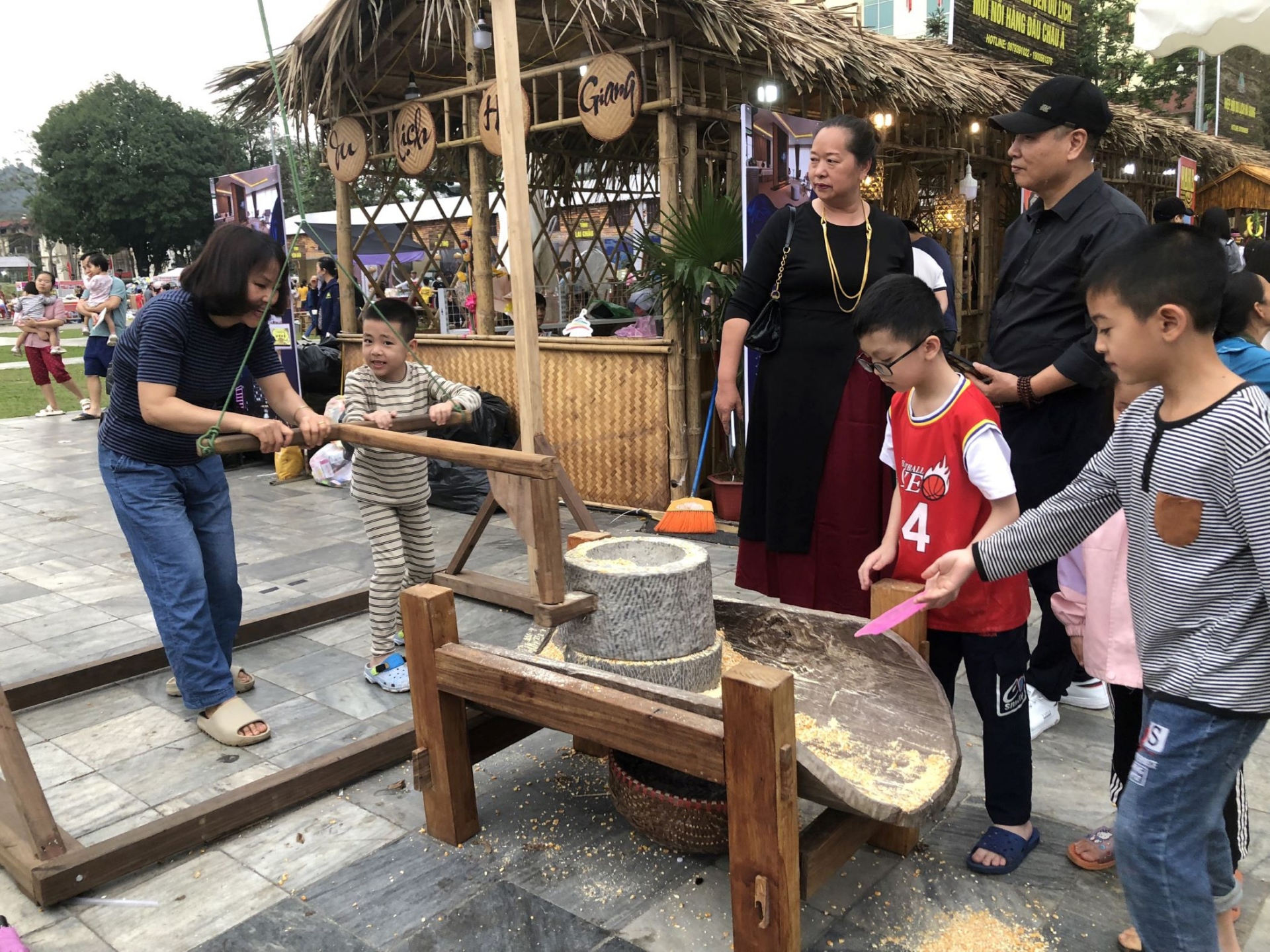 Trải nghiệm xay bột ngô trong văn hóa người dân tộc Mông tại lễ hội.